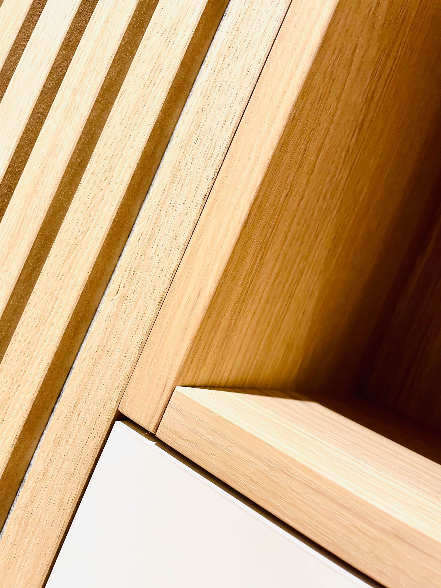 Holzpaneele mit einer weißen Ecke, die Schatten zeigt.