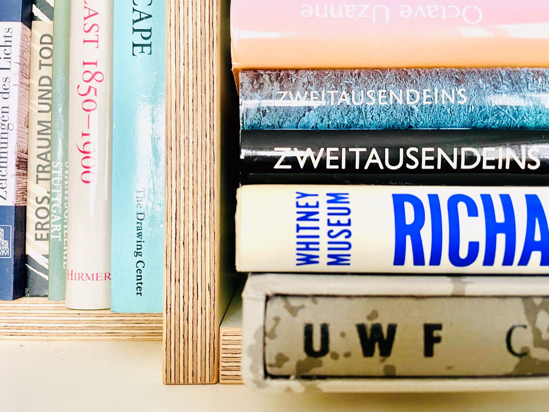 Books on a shelf, spines visible. Titles include