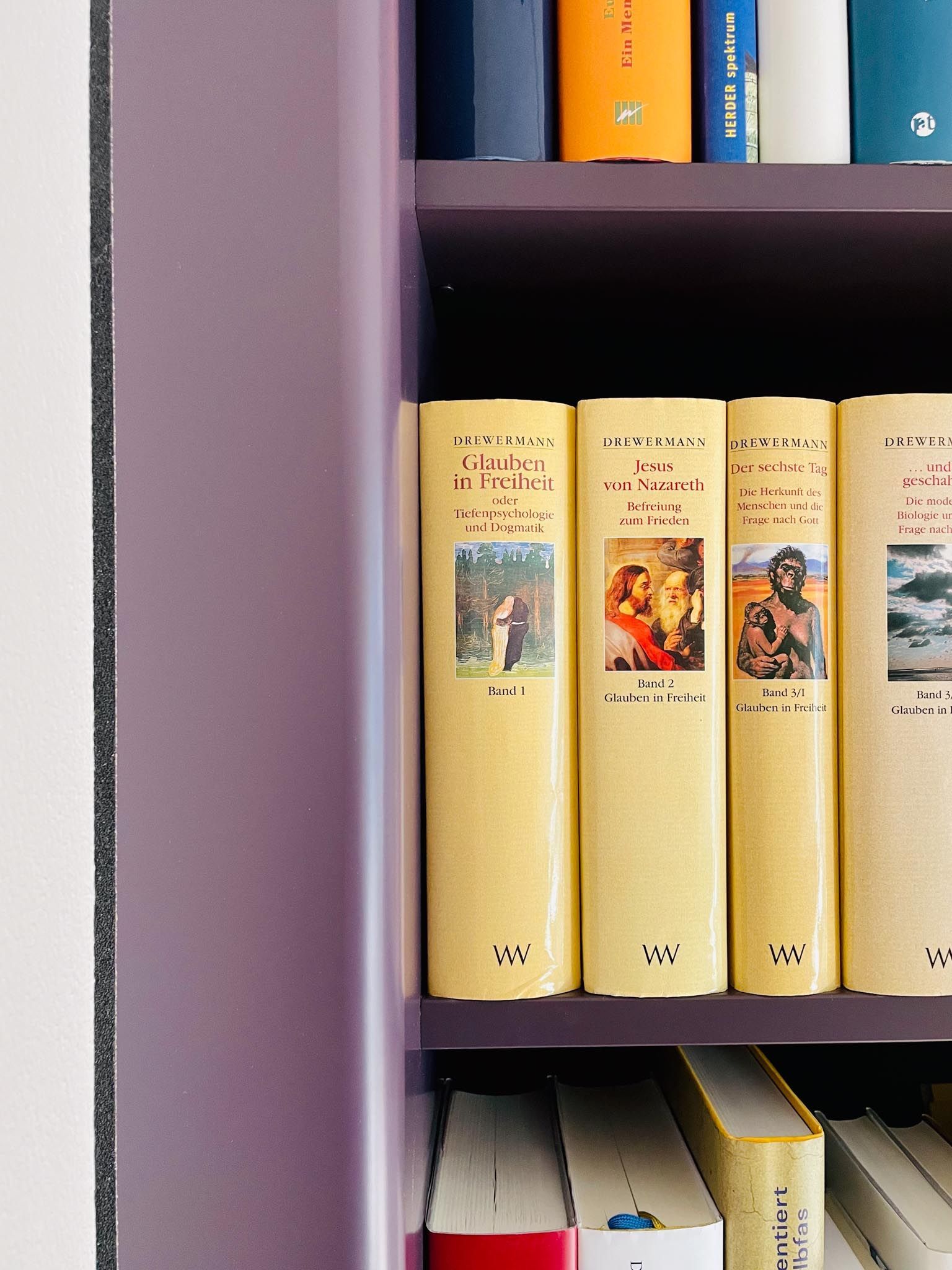 Bücherregale mit lavendelfarbener Farbe, in denen verschiedene Bücher stehen.