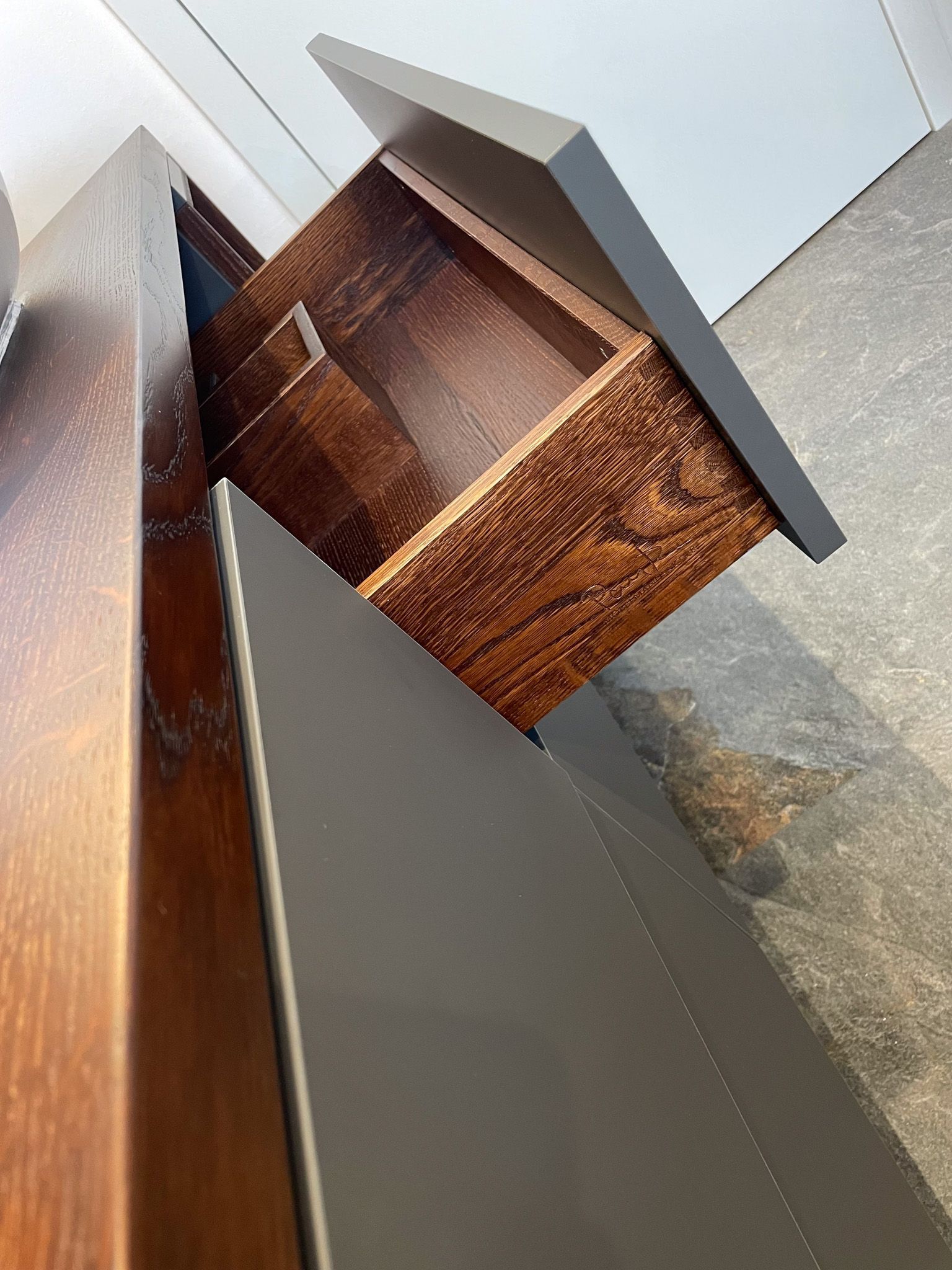 Dunkle Holzschublade aus einem dunkelfarbigen Schrank.