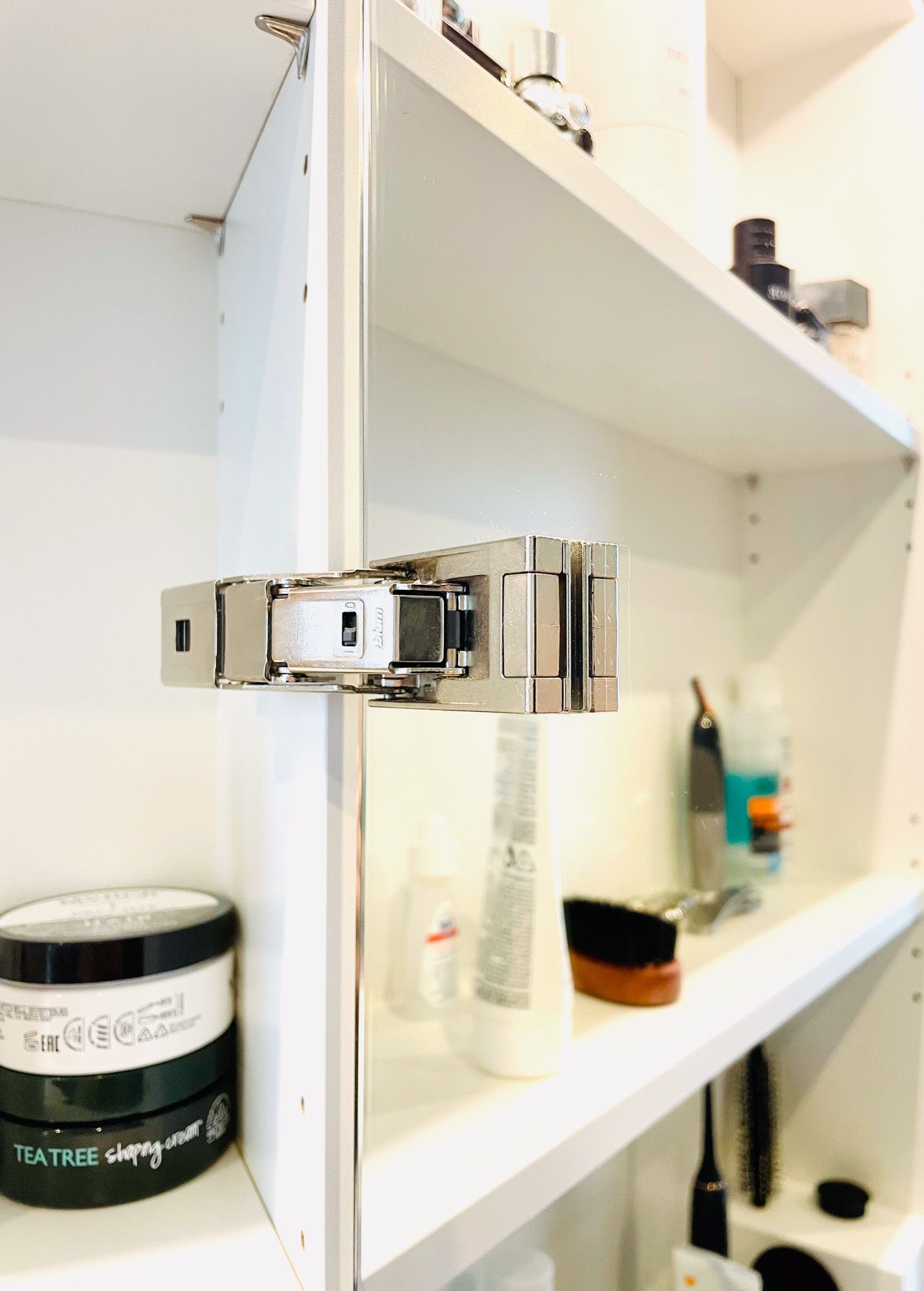 Eine Nahaufnahme eines Regals mit Metallbeschlägen, mit Produkten auf den anderen Regalen des Schranks.