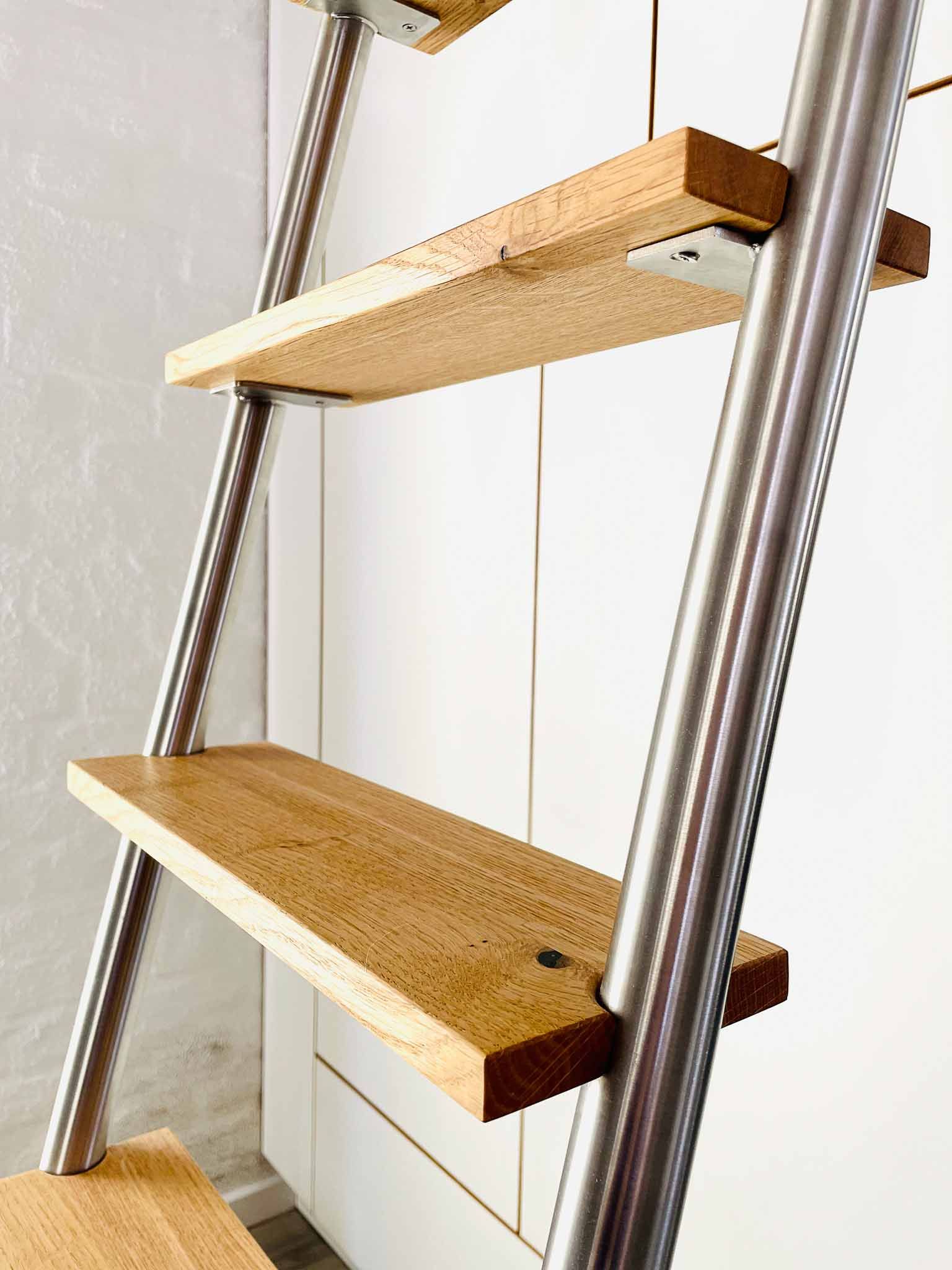 Von Metallstangen getragene Holzstufen, die an einer Wand befestigt sind.