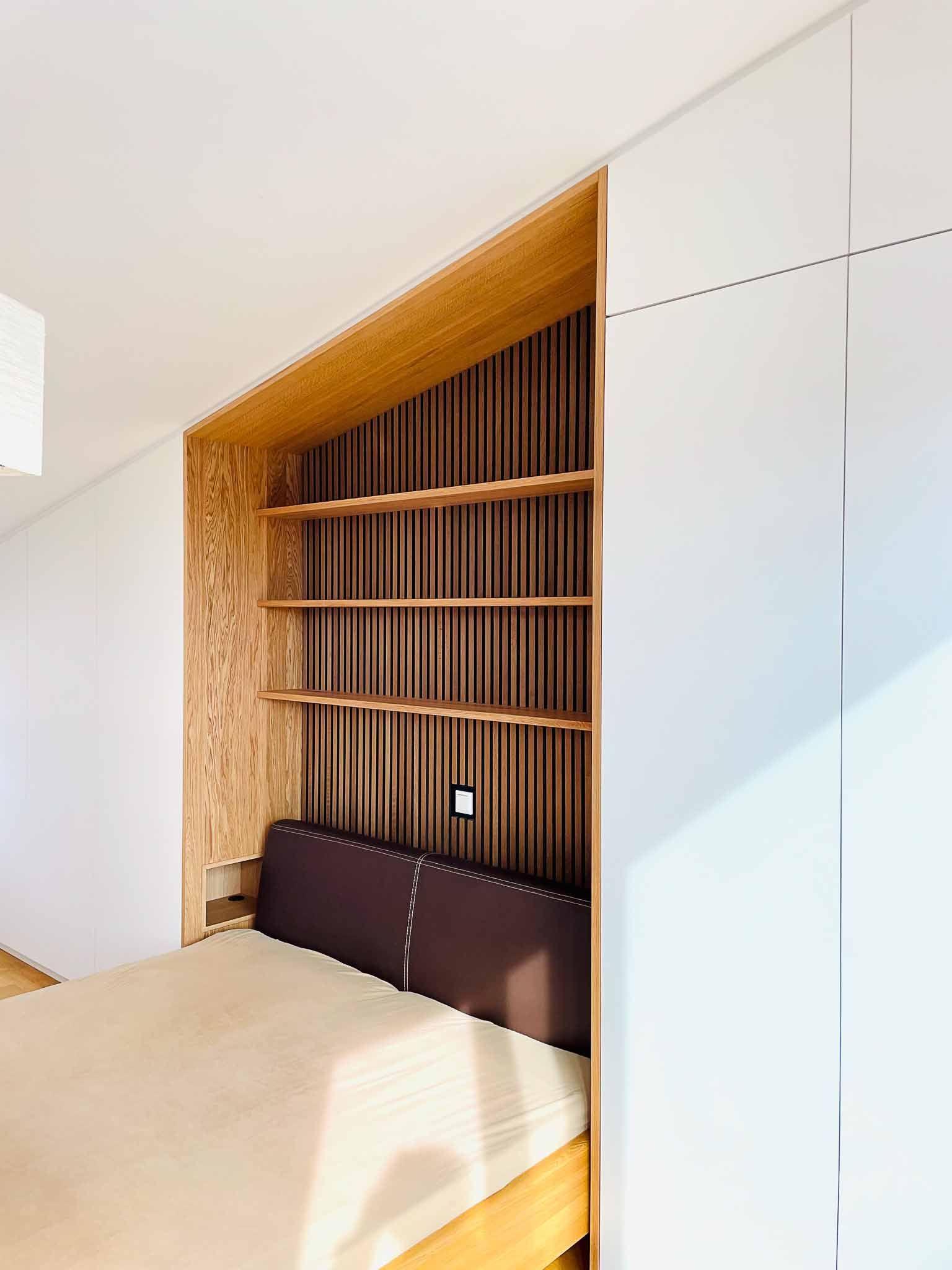 Schlafzimmerecke mit Bett, Regalen und braunem Kopfteil in einer Holzrahmenwand.