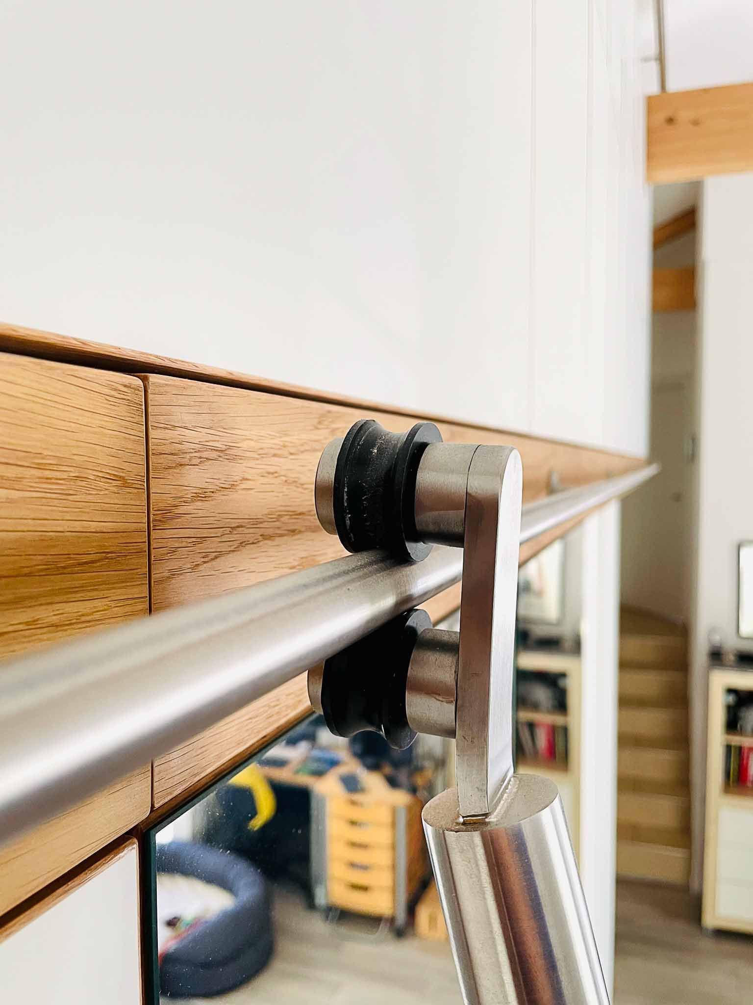 Schiebetürbeschläge aus Edelstahl, auf Holzverkleidung montiert.