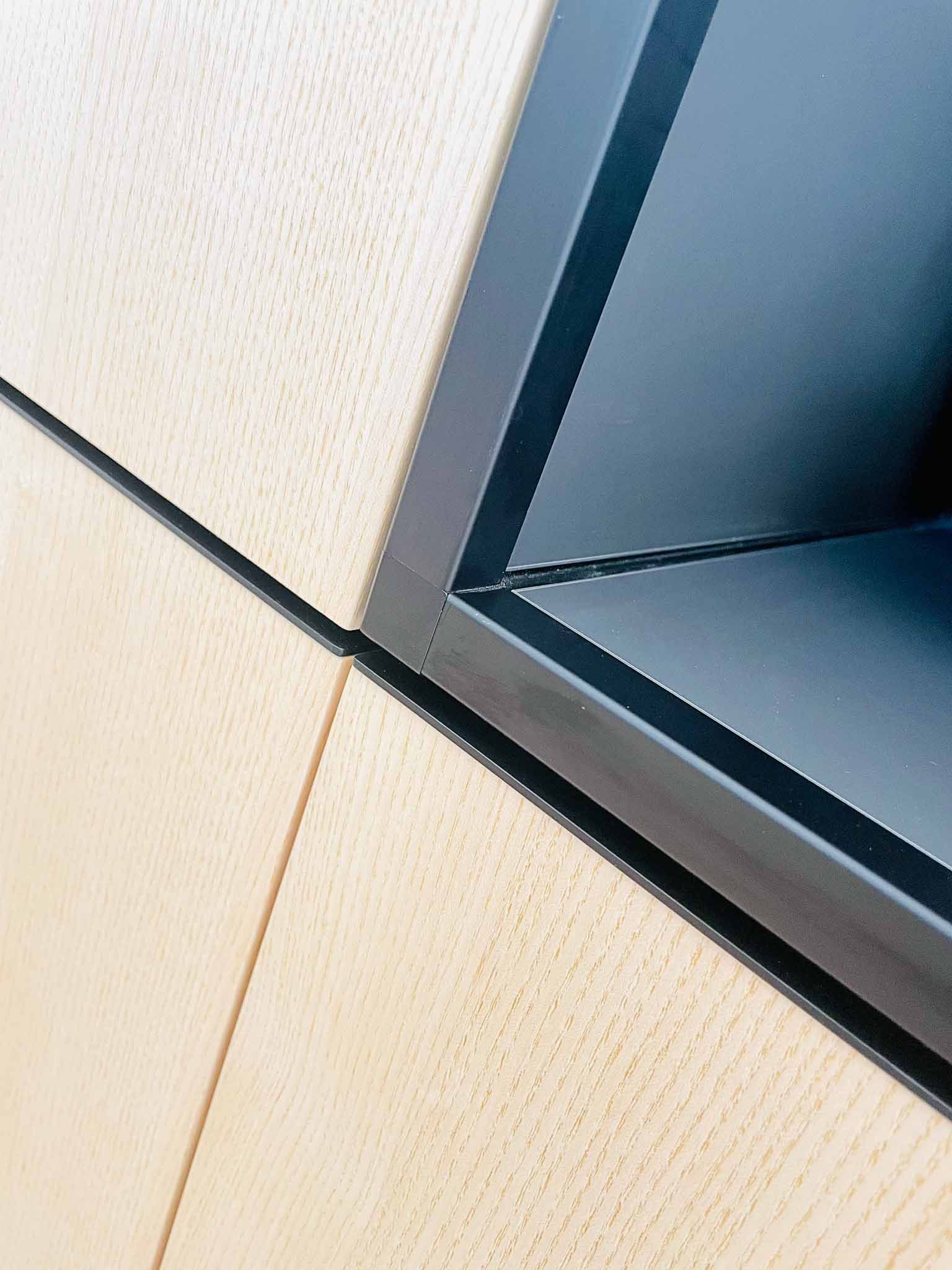 Helle, strukturierte Wandpaneele mit dunklem, eckigem Einsatz.