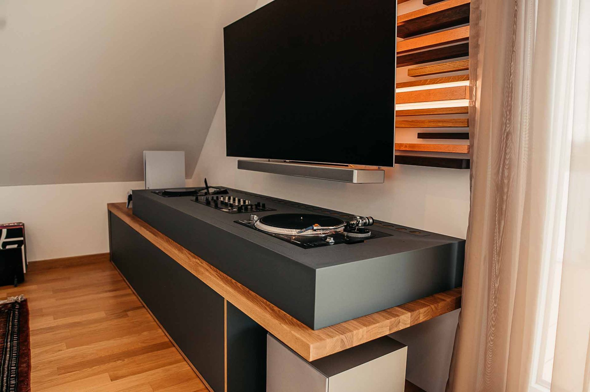 Moderne Medienkonsole mit Plattenspieler, Fernseher und Akzentwand aus Holz.