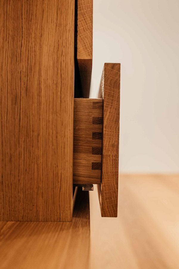 Nahaufnahme einer offenen Holzschublade mit sichtbaren Schwalbenschwanzverbindungen, hellbraunes Holz.