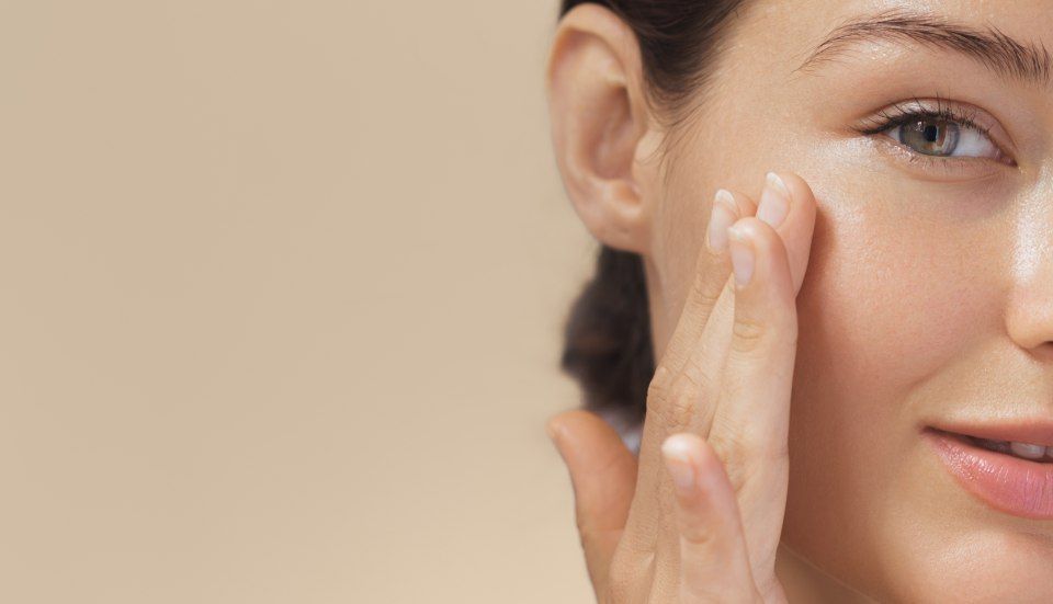 Eine Frau cremt ihr Gesicht ein. Petra's Kosmetik-Studio