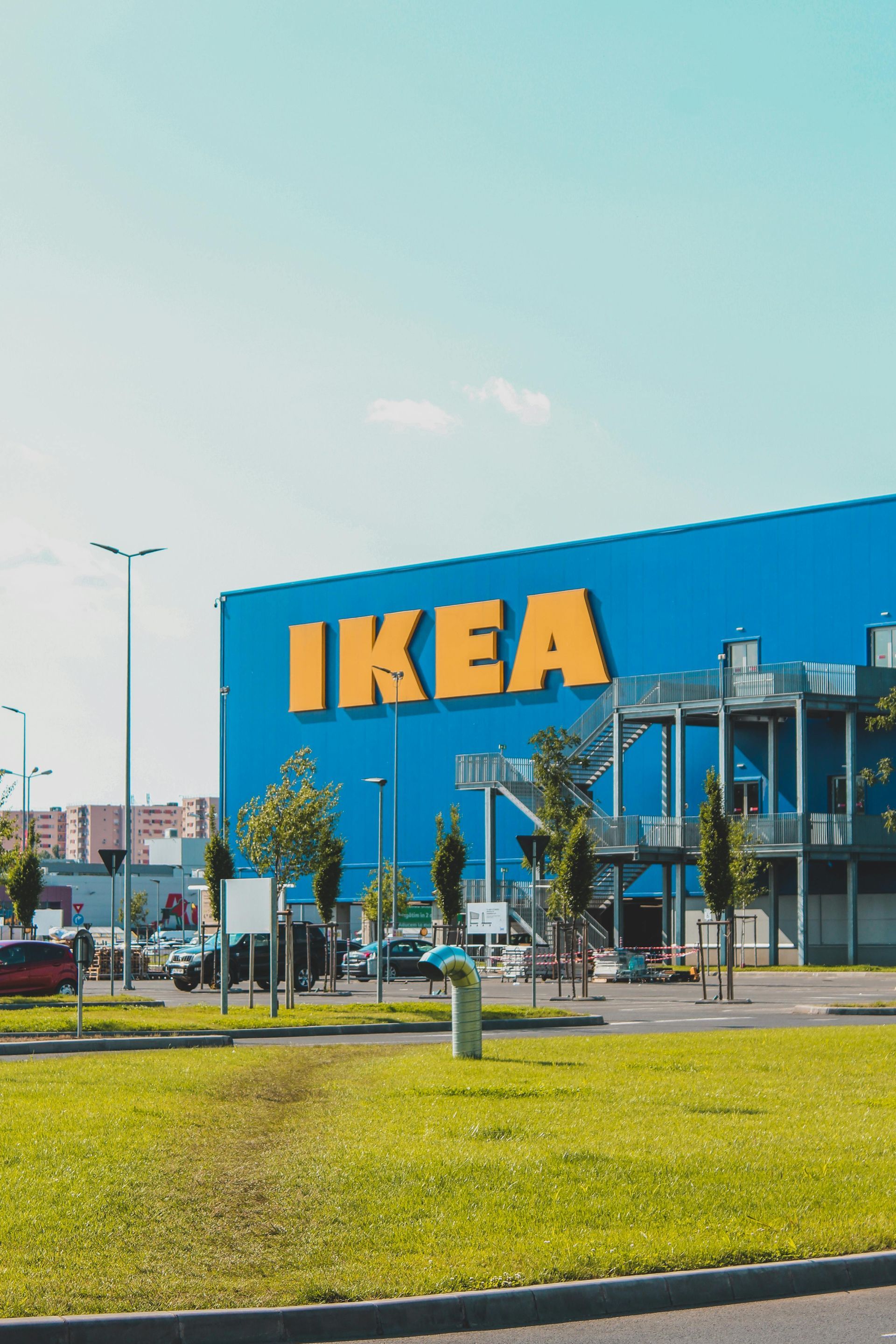 Exterior de una tienda IKEA con fachada azul y logotipo amarillo, visto desde una rotonda