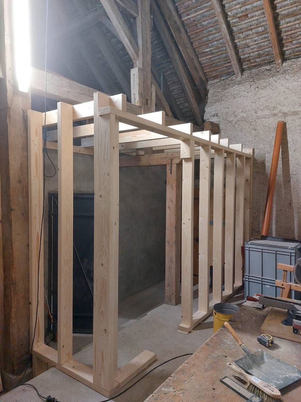 Structure à ossature bois construite à l'intérieur d'une grange, servant éventuellement de porte ou de pièce.