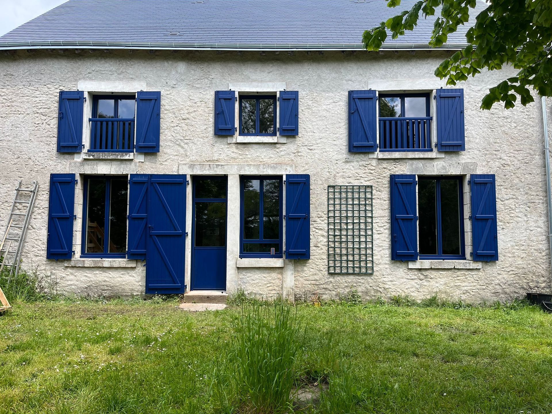 Maison avec six fenêtres et volets bleu foncé