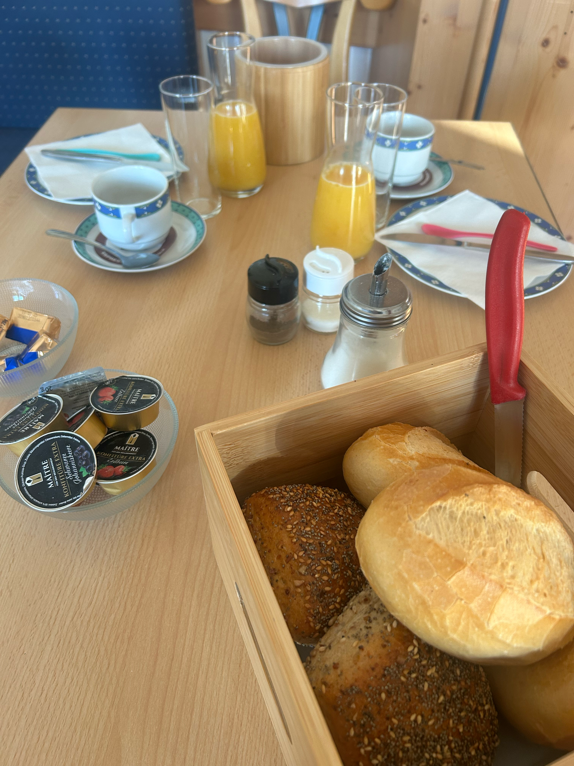 Frühstücksteller mit Eiern, Speck, Pfannkuchen, Toast, Kaffee und Saft.