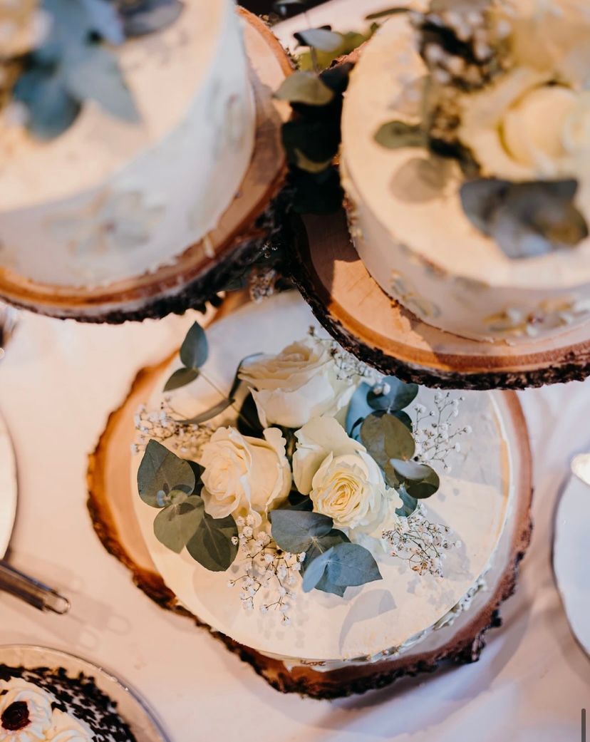 Beeren-Schichtkuchen mit rosa Zuckerguss, Himbeeren, Blaubeeren und Brombeeren auf einer schwarzen Schieferplatte.