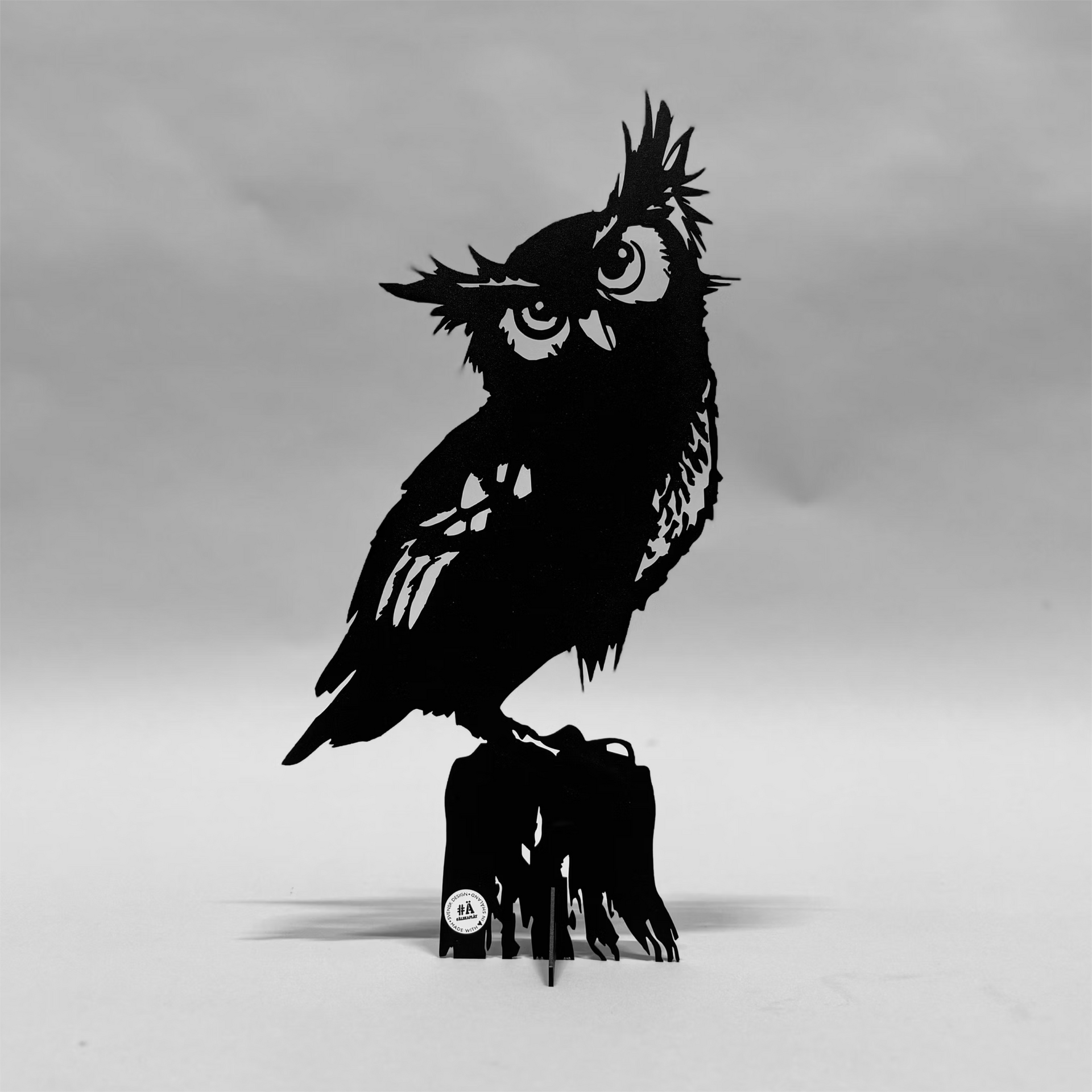 Ein Foto einer Eule, die auf einem Baumstumpf sitzt