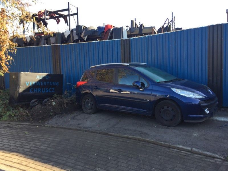 dunkles Auto vor einem Container