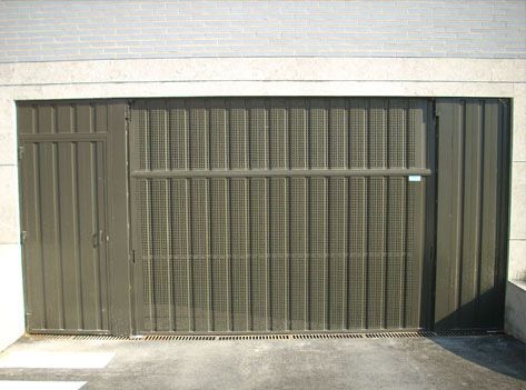 Una puerta de garaje con una pared de ladrillos detrás
