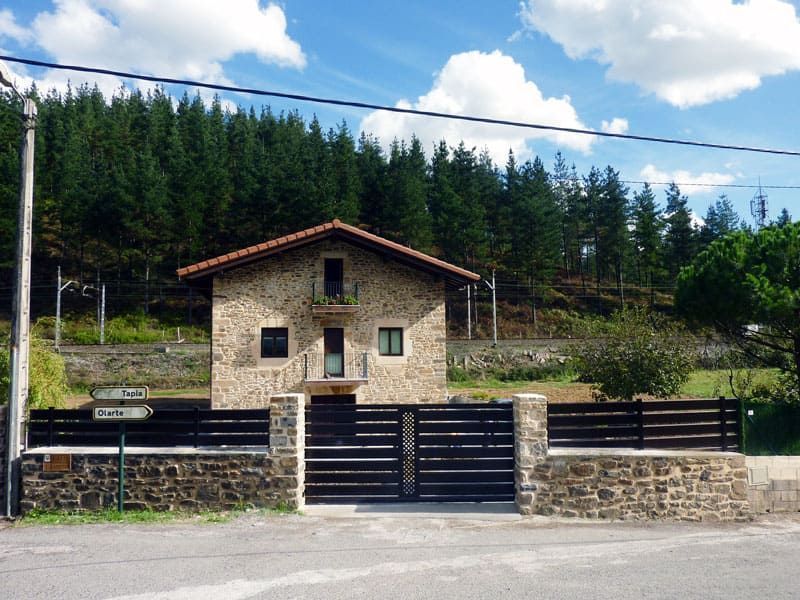 Una casa de piedra con una valla de madera delante