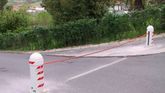 Un poste blanco con rayas rojas está al costado de una carretera.