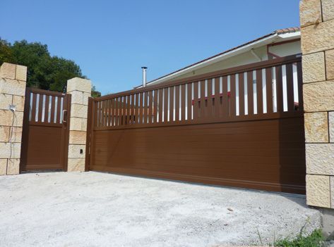 Una casa con una puerta corrediza y un muro de piedra
