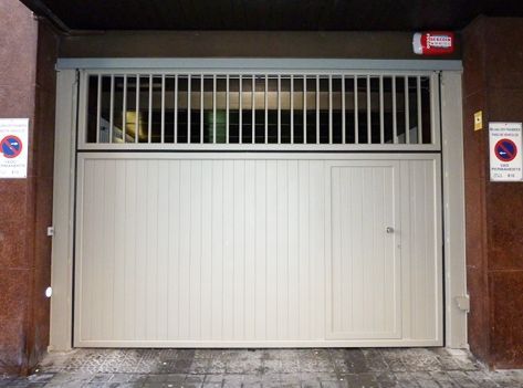 Una puerta de garaje blanca con un extintor rojo encima.