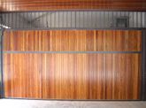 Una puerta de garaje de madera con marco de metal en un garaje.