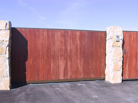 Una puerta de madera roja está rodeada de pilares de piedra.