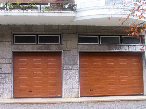 Dos puertas de garaje de madera en el lateral de un edificio.