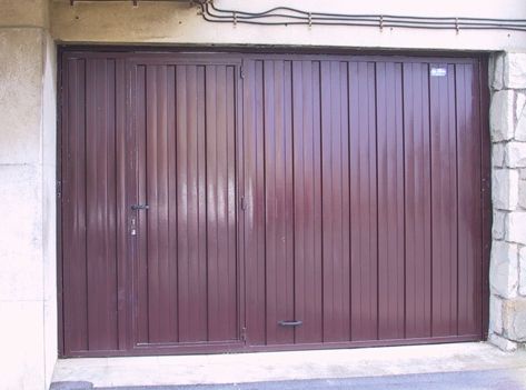 Una puerta de garaje marrón con una pared de ladrillos detrás.