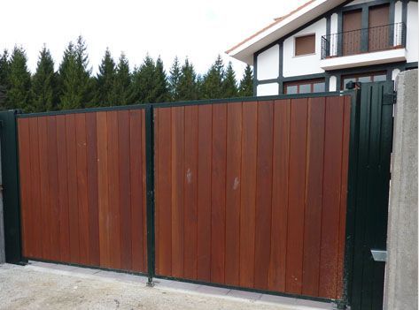 Una puerta de madera con marco negro está frente a una casa.