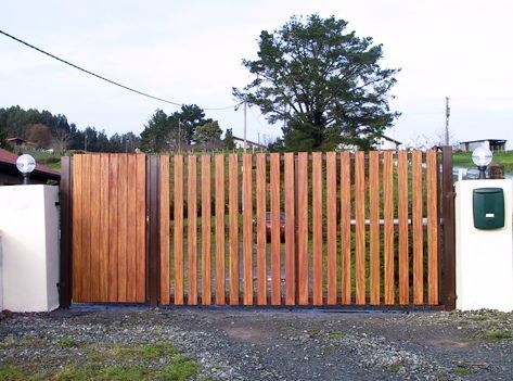 Una valla de madera con un buzón delante.