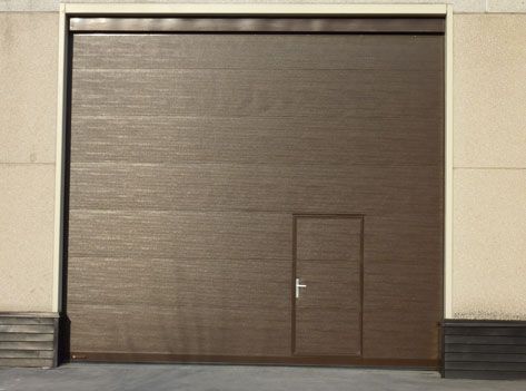 Una puerta de garaje marrón con una pequeña puerta debajo.