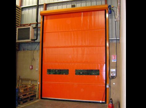 Una gran puerta naranja está abierta en un almacén.