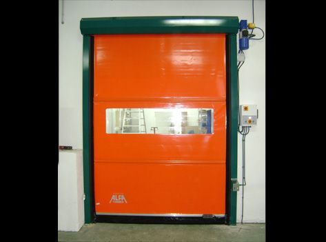 Una gran puerta naranja con un marco verde está en una habitación.