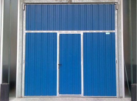 Una puerta de garaje azul está encima de una pared de hormigón.