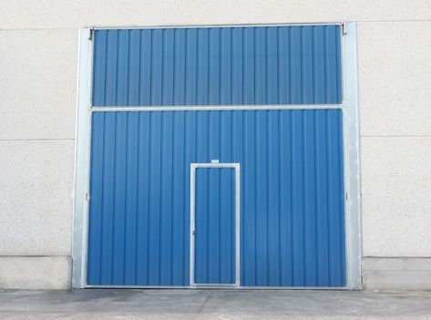 Una puerta azul con una pequeña puerta en el medio