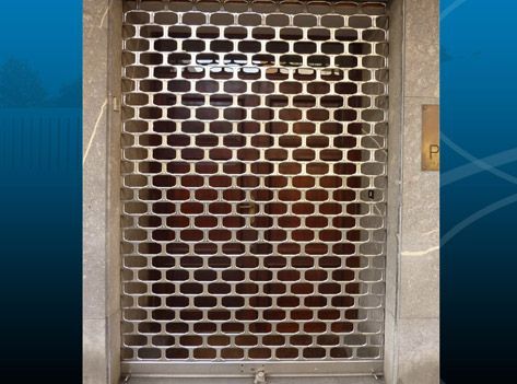 Una puerta de ladrillo con una reja de metal.