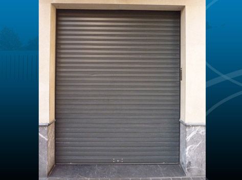 Una puerta de garaje gris está abierta en un edificio.