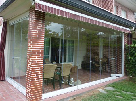 Un patio con pared de ladrillo y puertas corredizas de vidrio.