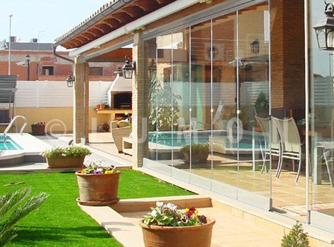 Una casa con piscina y patio con puertas corredizas de vidrio.