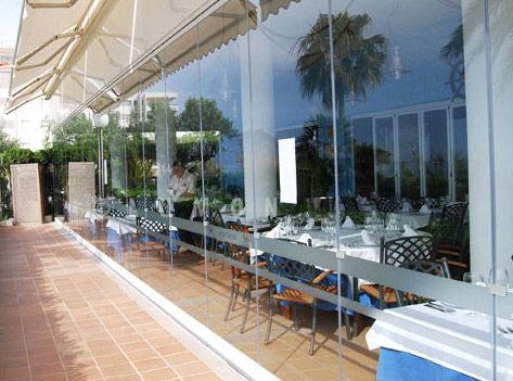 Un restaurante con mesas y sillas frente a una pared de cristal.