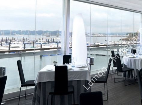 Un restaurante con mesas y sillas y vista al agua.