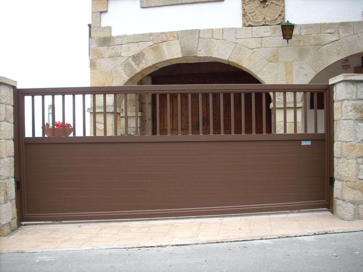 Una puerta corrediza marrón frente a un edificio de piedra.
