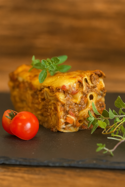 Bœuf séché tranché sur une planche à découper en bois sur fond noir.