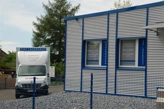 Ein weißer Lieferwagen steht vor einem Gebäude.