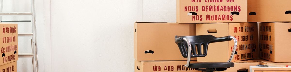 In einem Raum sind mehrere Kartons übereinander gestapelt.