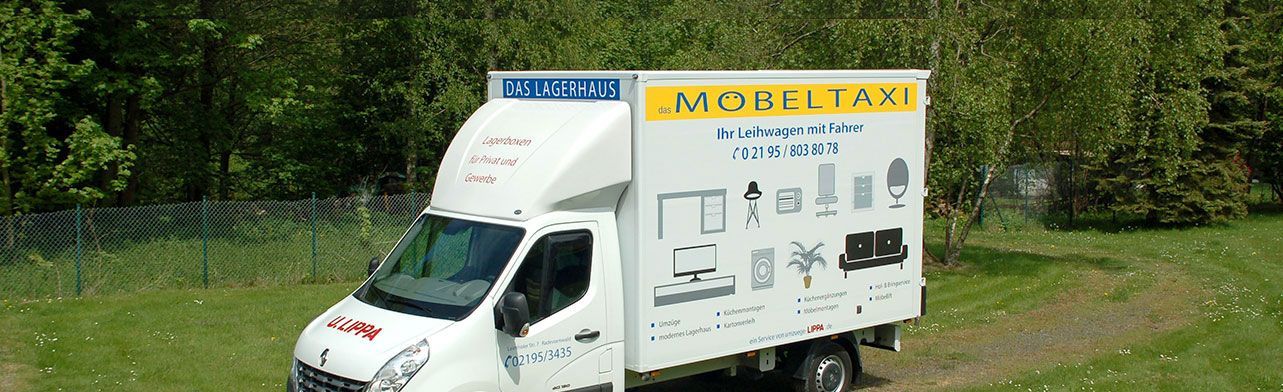 Ein weißer Lastwagen ist auf einer Wiese geparkt.