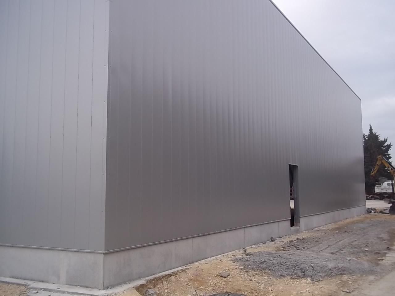 Côté d'un bâtiment en métal avec une porte d'accès