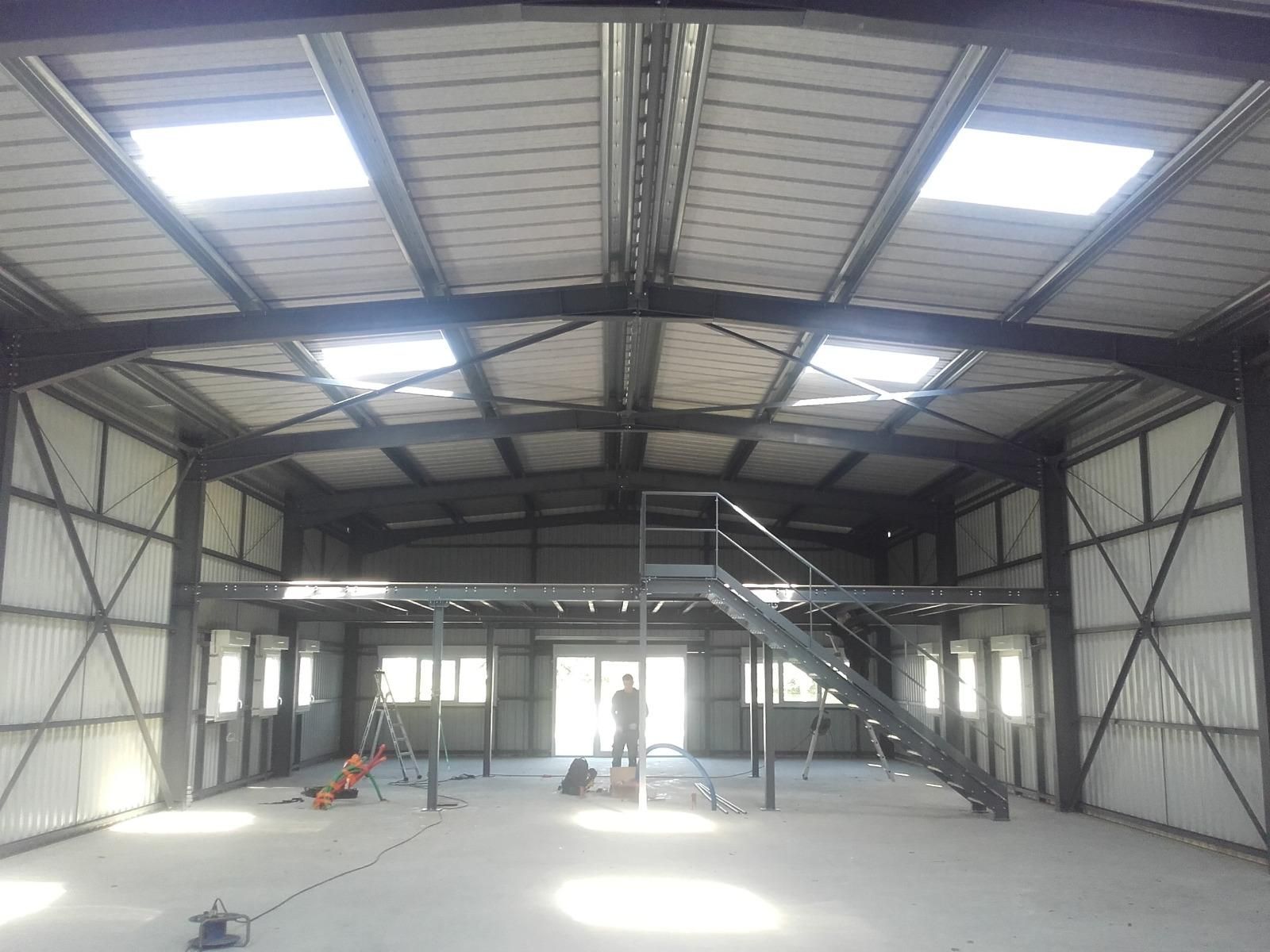 Vue intérieure du hangar avec l'escalier et la mezzanine en métal