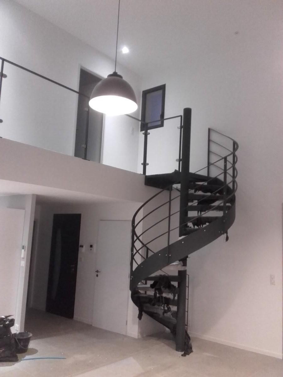 Vue d'un escalier hélicoïdal moderne menant à une mezzanine