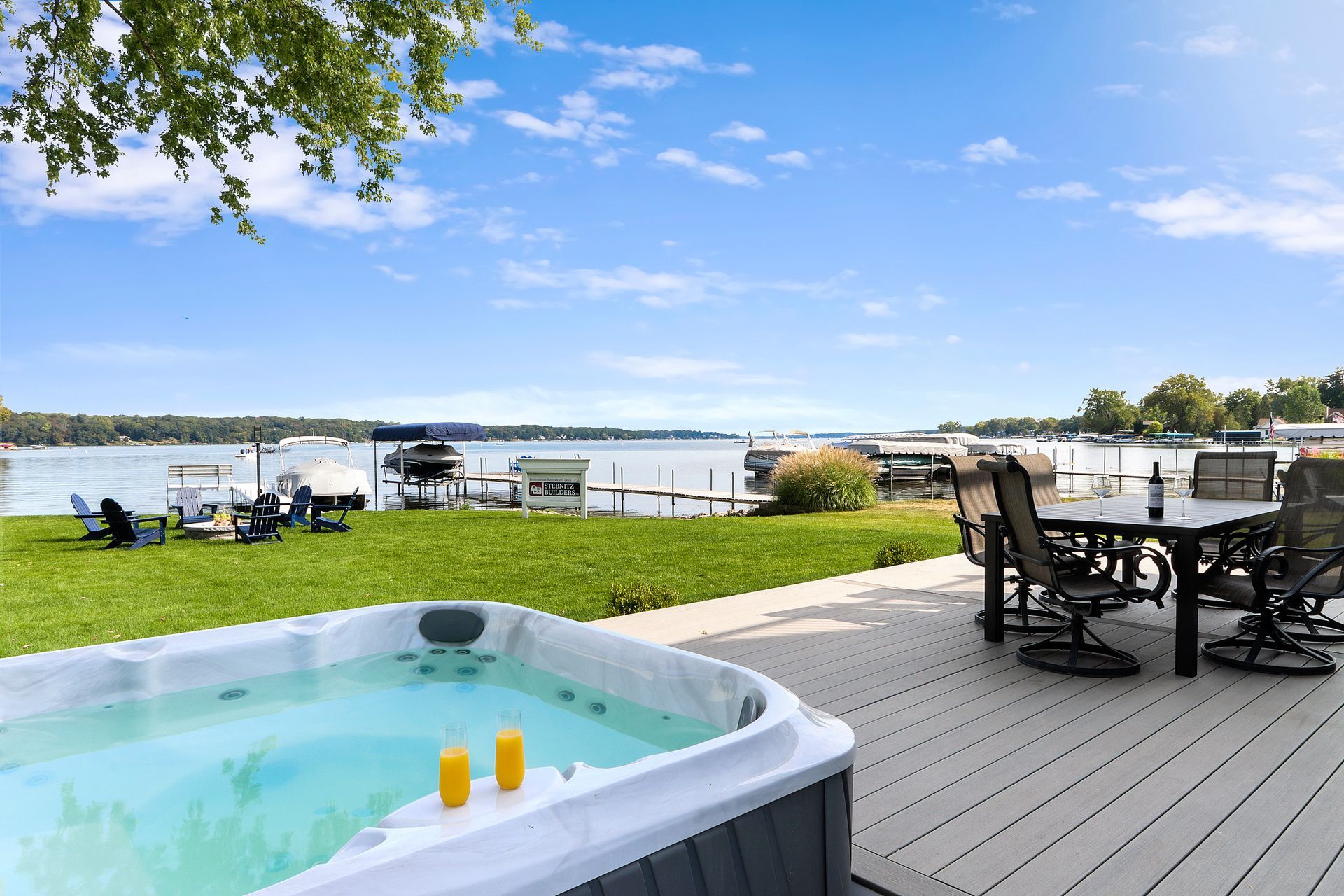 A hot tub is sitting on a deck next to a lake.